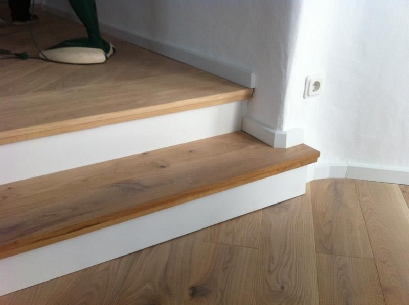 Eine Treppe mit Holzstufen und weißen Zierleisten