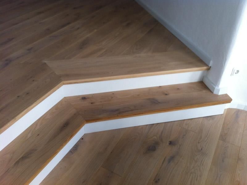 Eine Treppe aus Holz und weißen Zierleisten