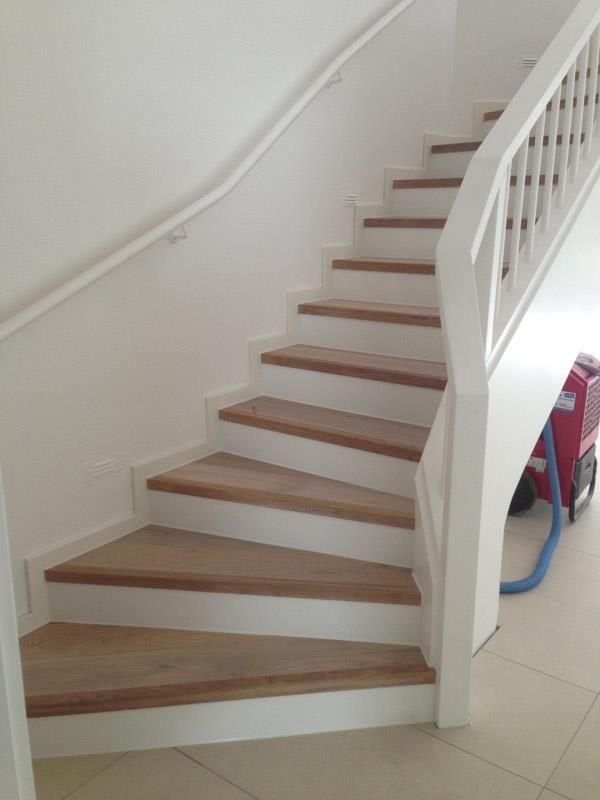 Eine Treppe mit Holzstufen und einem weißen Geländer