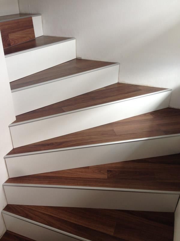 Eine Wendeltreppe mit Holzstufen und weißen Stufen