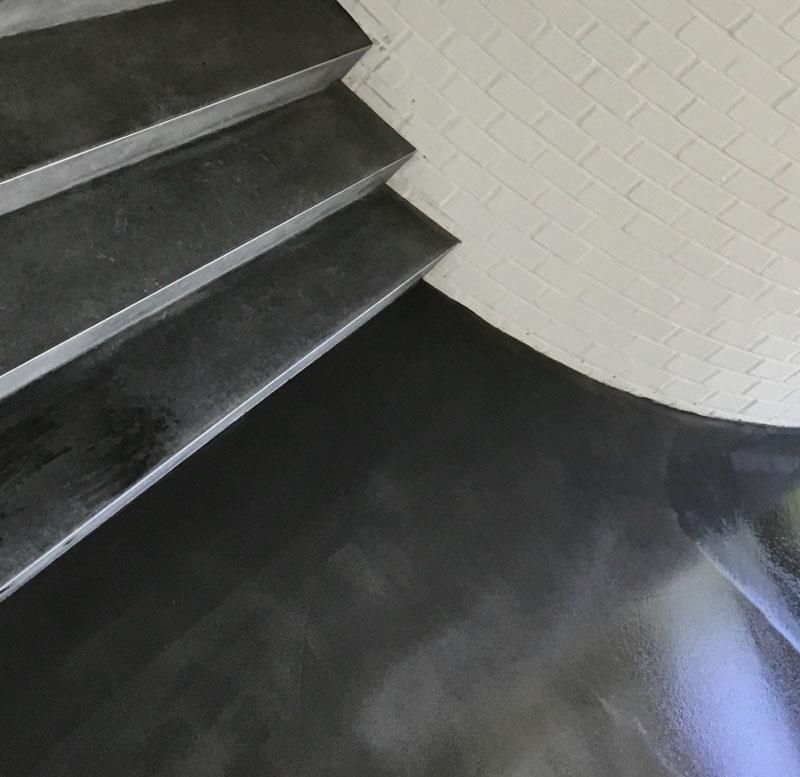 Eine schwarze Treppe mit einer weißen Ziegelwand im Hintergrund