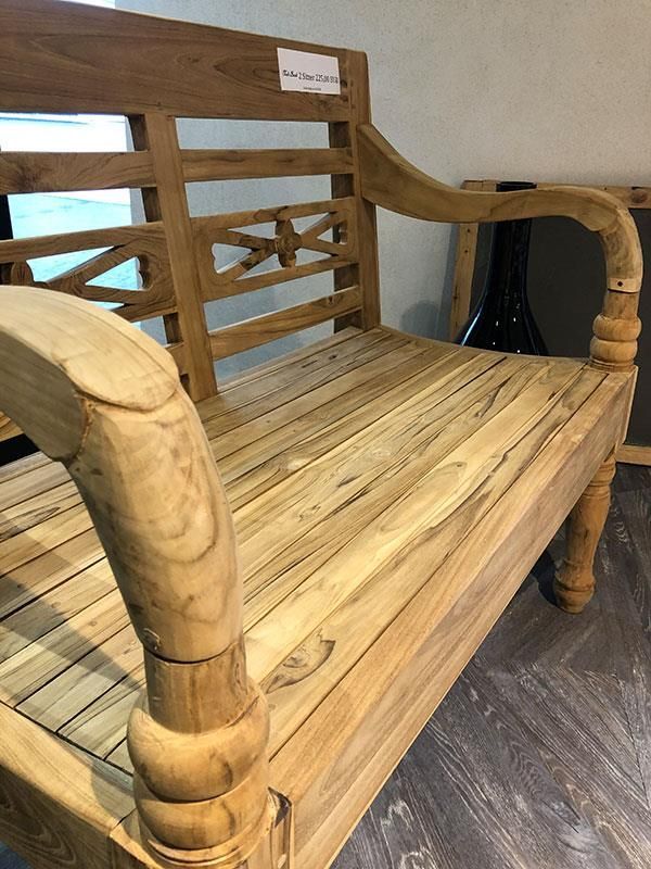 In einem Raum steht eine Holzbank auf einem Holzboden.