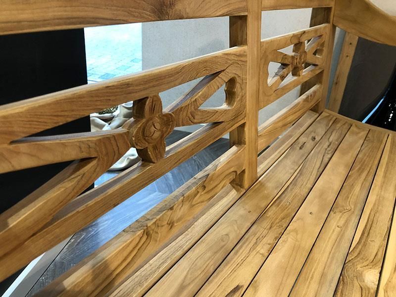 Eine Holzbank mit einem geschnitzten Muster auf der Rückseite