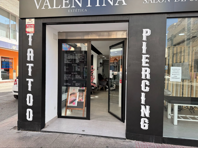 Una tienda de tatuajes con un cartel que dice piercing