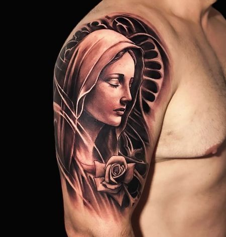 Un hombre tiene un tatuaje de una mujer con una rosa en el brazo.