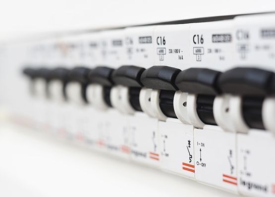 Fila de interruptores automáticos blancos y negros en un panel eléctrico, etiquetados como C16.