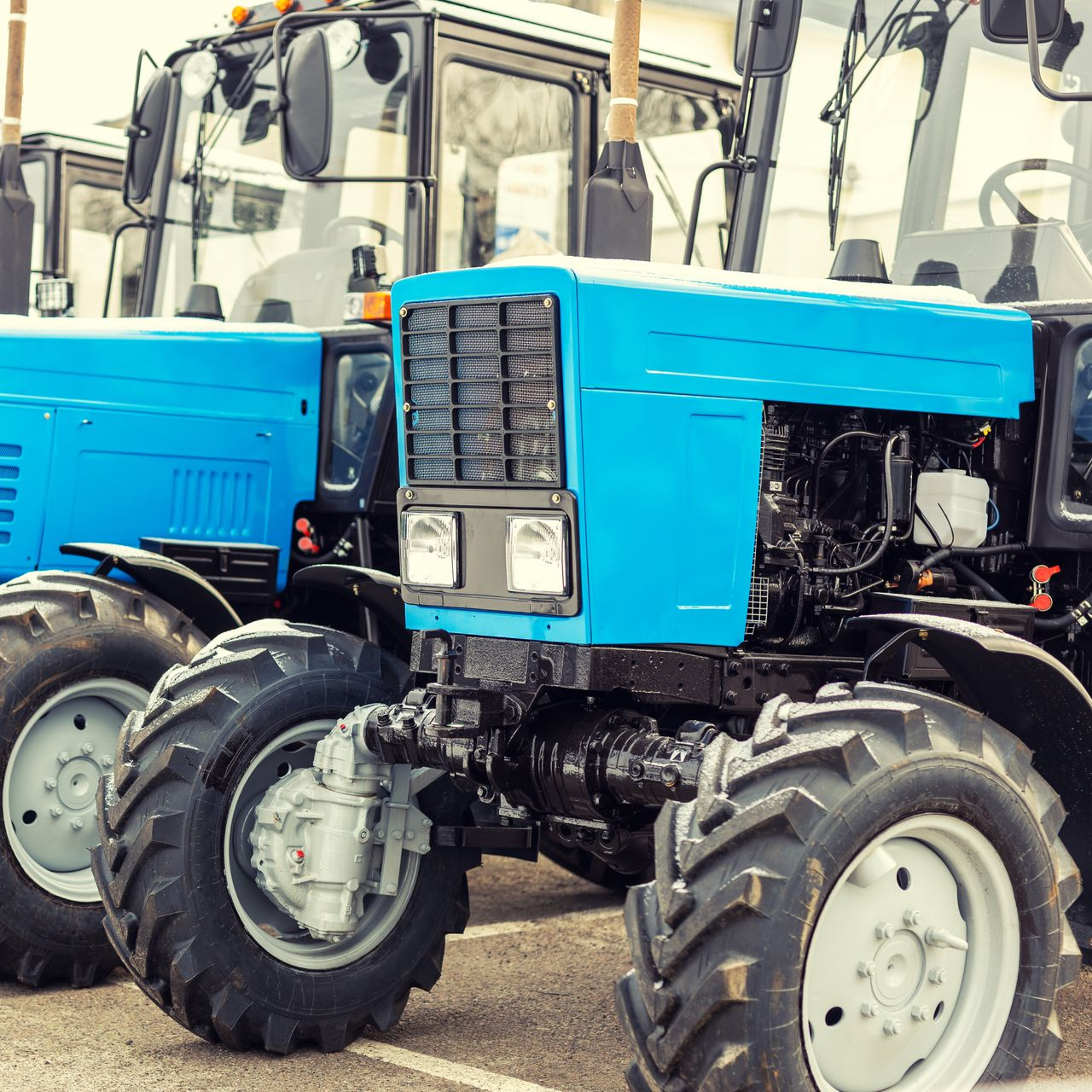 Tracteurs bleus garés à l'extérieur.