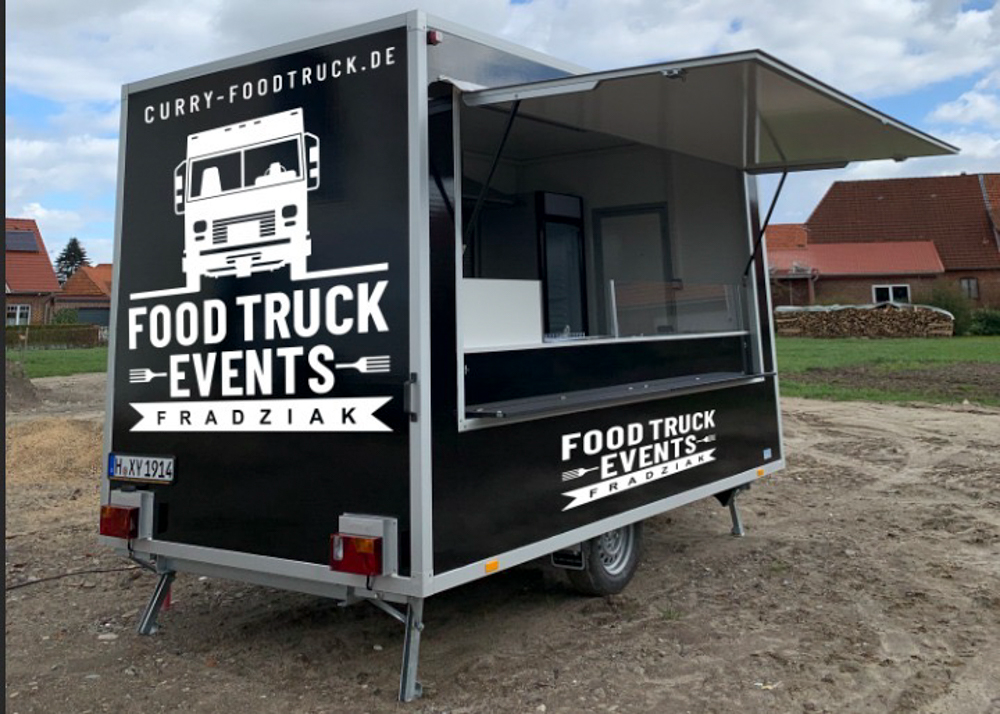 Ein Imbisswagen steht auf einem Feld.