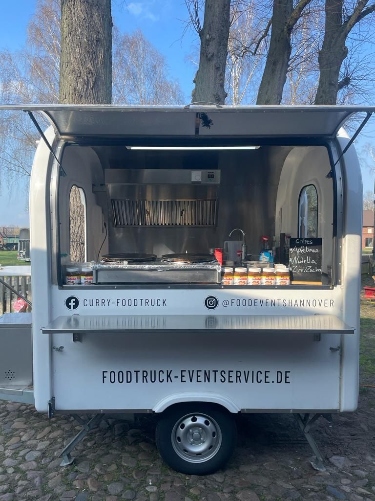 Ein Imbisswagen steht mit offener Tür am Straßenrand.