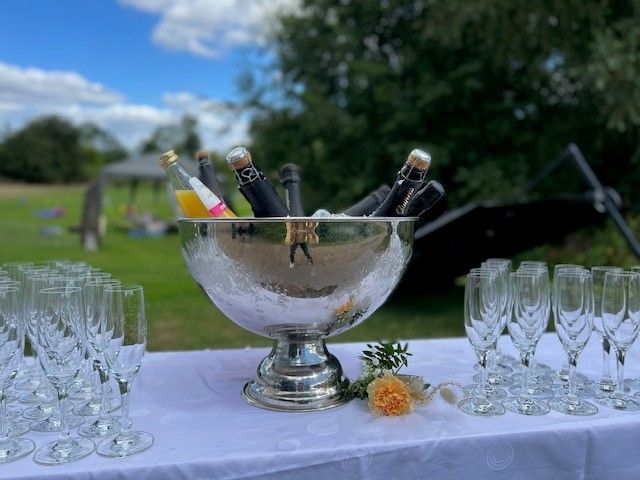 Ein Kübel Champagner steht neben Weingläsern auf einem Tisch.