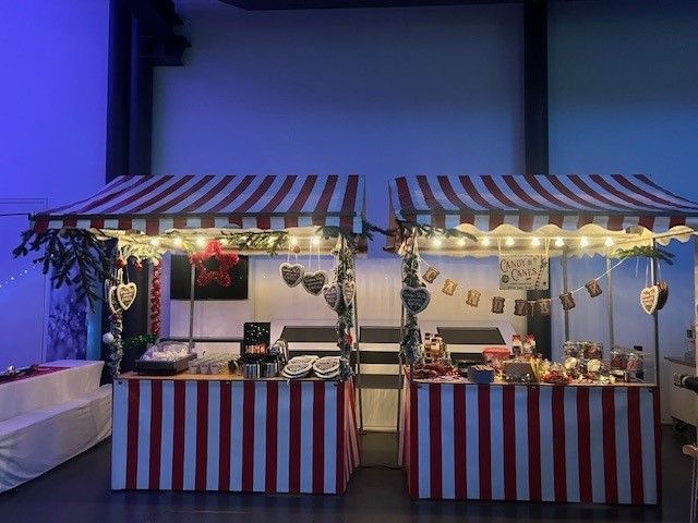 Zwei rot-weiß gestreifte Zelte stehen nebeneinander in einem Raum.