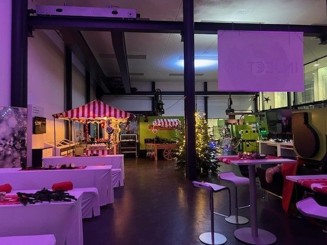 Ein großer Raum mit Tischen und Stühlen und einem Popcornwagen.