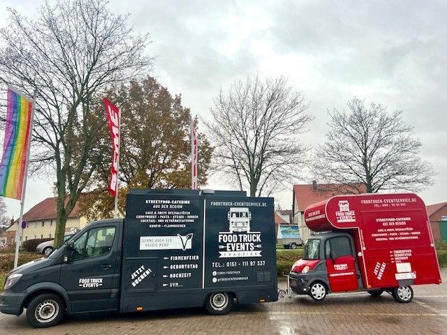 Auf einem Parkplatz stehen zwei Imbisswagen nebeneinander.