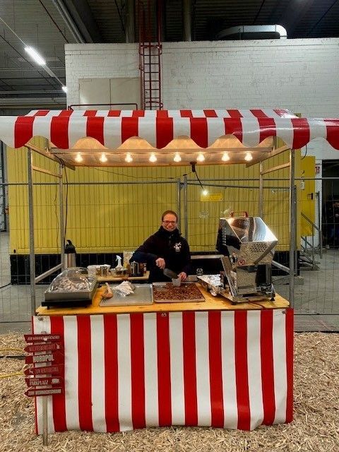 Ein Mann steht hinter einem rot-weiß gestreiften Zelt