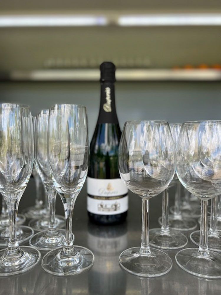 Eine Flasche Champagner steht neben einer Reihe Weingläser.