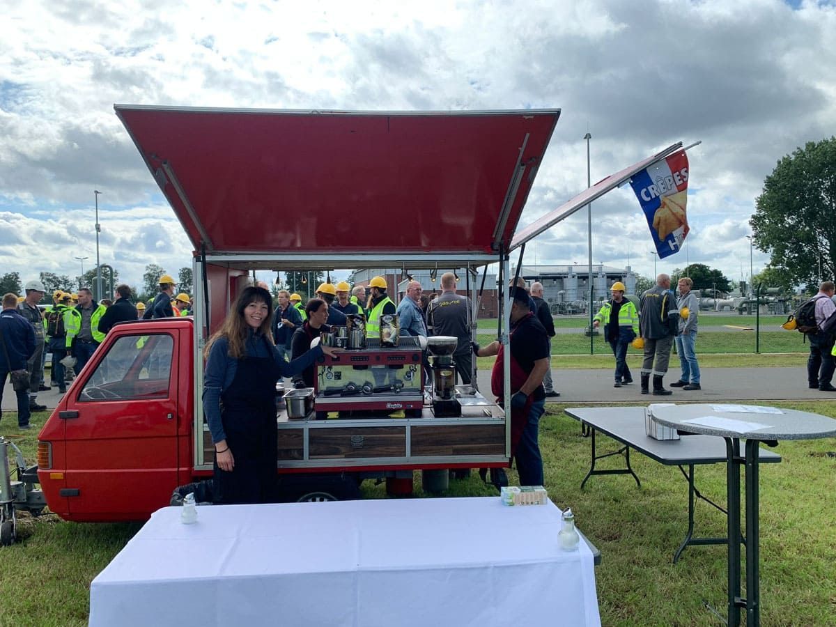 Eine Frau steht vor einem roten Imbisswagen.