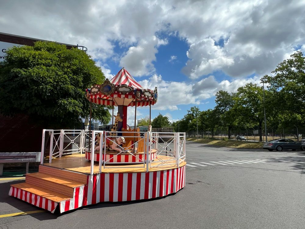 Mitten auf einem Parkplatz steht ein Karussell.