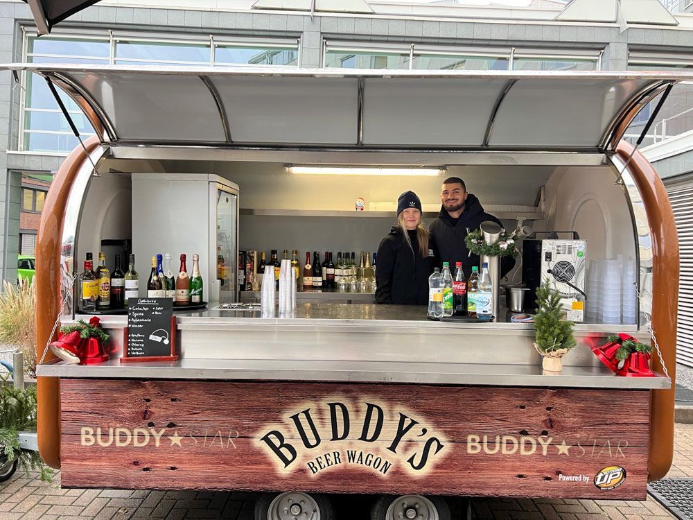 Ein paar Leute stehen vor einem Imbisswagen.