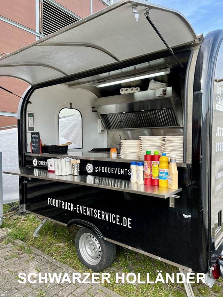 Vor einem Gebäude parkt ein Imbisswagen.