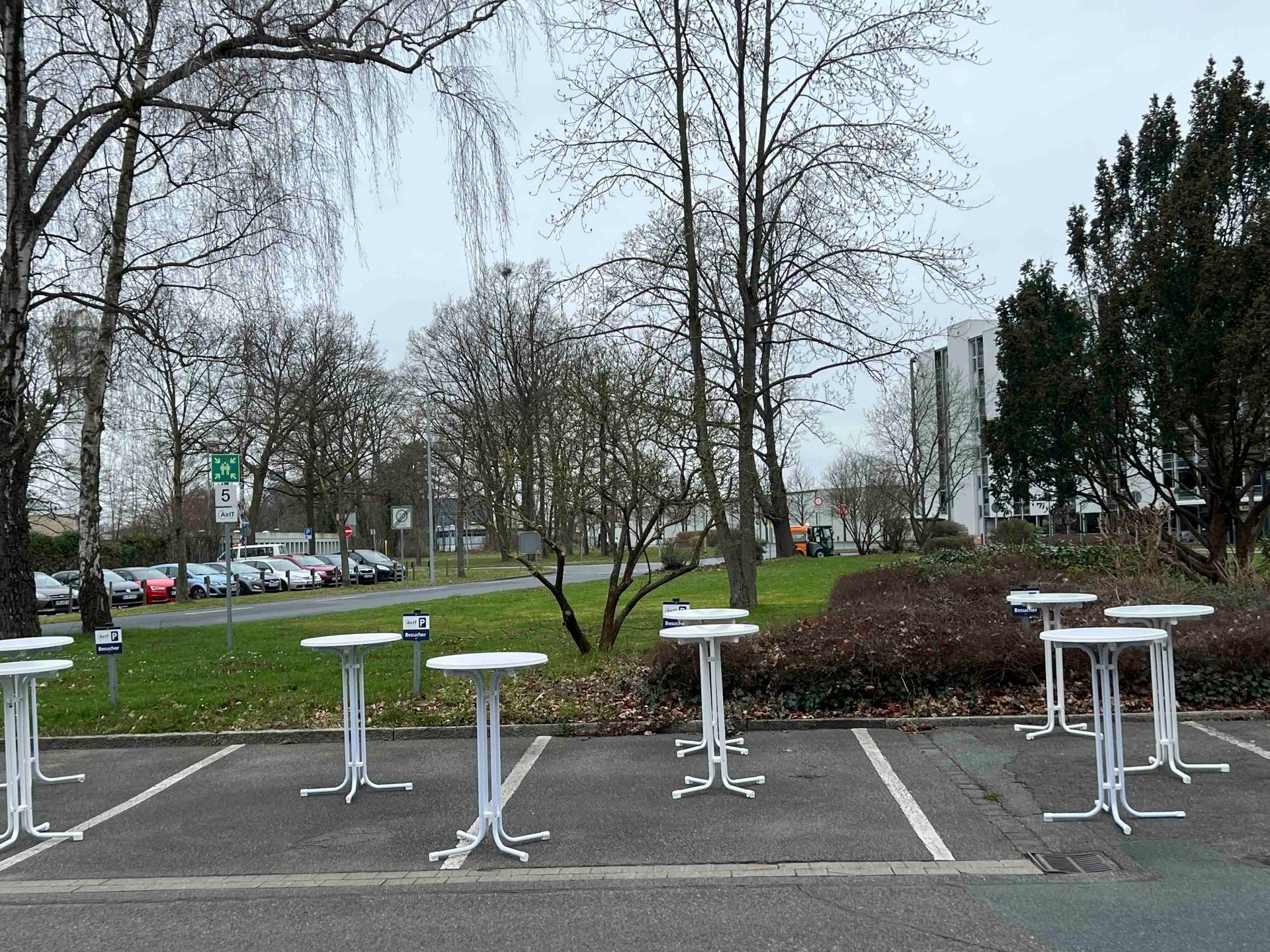 Auf einem Parkplatz steht eine Reihe von Tischen.