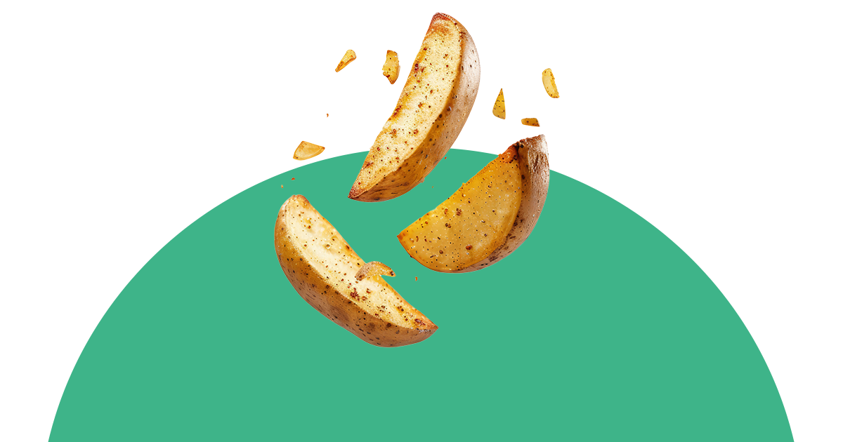 Kartoffelspalten fallen auf eine grüne Fläche.