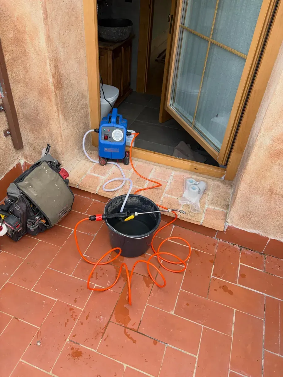 Herramienta eléctrica con cable instalada en un patio de terracota junto a una puerta corredera de cristal
