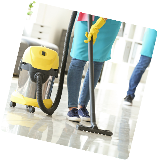 Une femme nettoie le sol avec un aspirateur