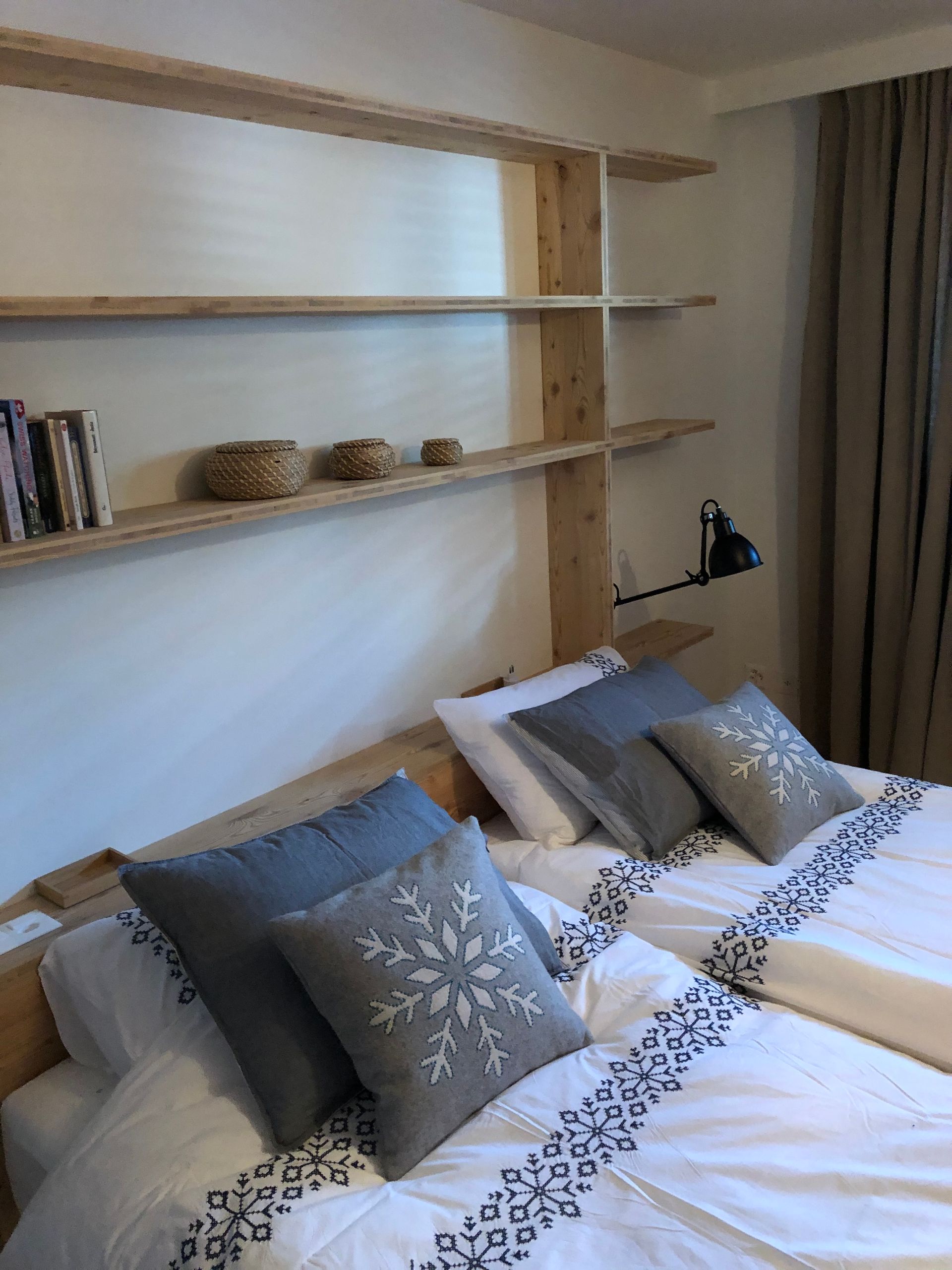 Eine Holzbank mit einem daran befestigten Tisch vor einem Fenster. Foto von der Holzprofi Zermatt AG