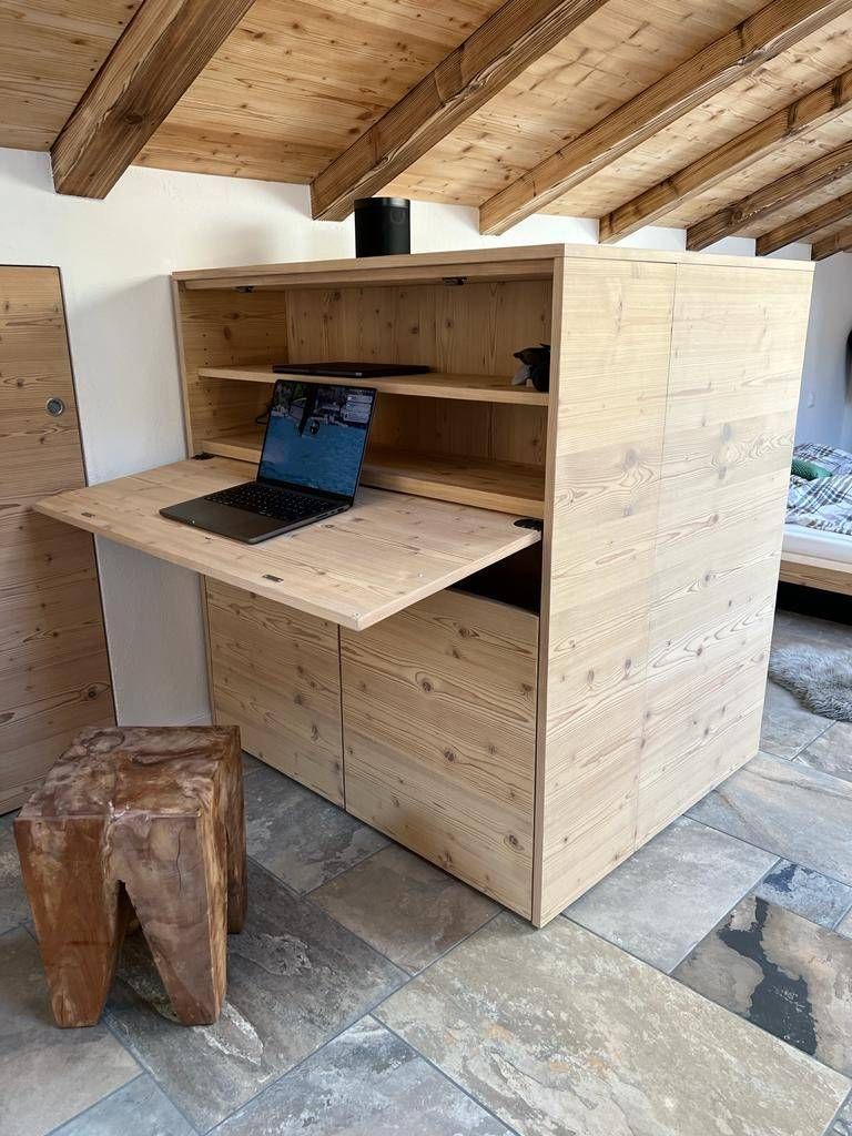 Ein Holzschreibtisch mit einem Laptop darauf in einem Zimmer. Foto von der Holzprofi Zermatt AG