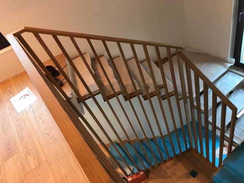 Eine Holztreppe mit einem Metallgeländer in einem Haus.  Foto von der Holzprofi Zermatt AG