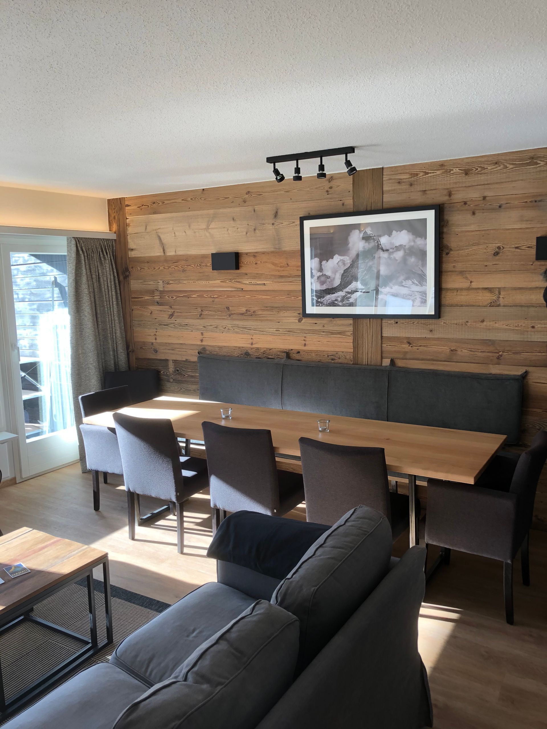 Ein Holzflur mit Tischen und Bänken in einer Hütte. Foto von der Holzprofi Zermatt AG