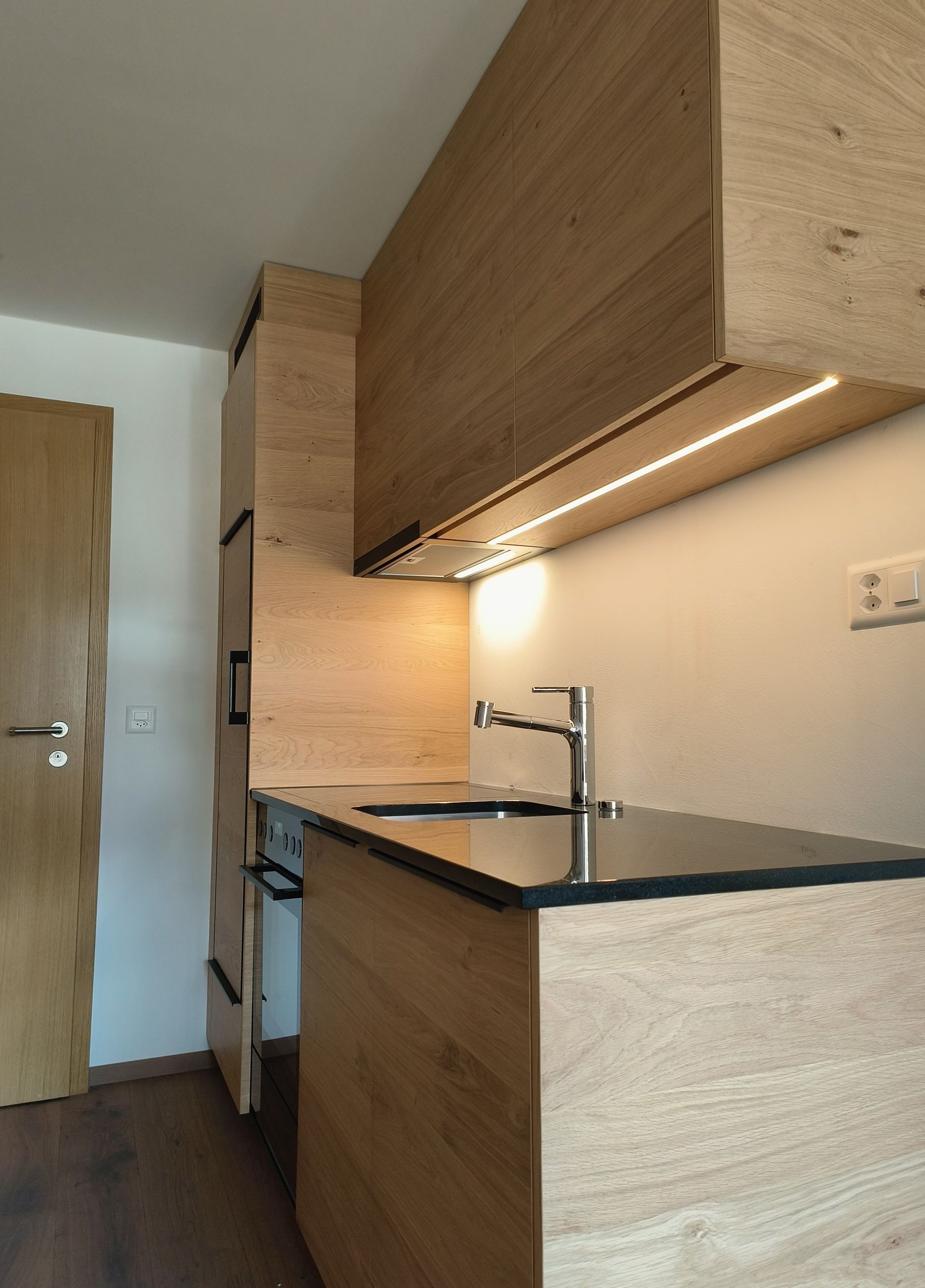 Eine Küche mit Spüle und Herd. Foto von der Holzprofi Zermatt AG