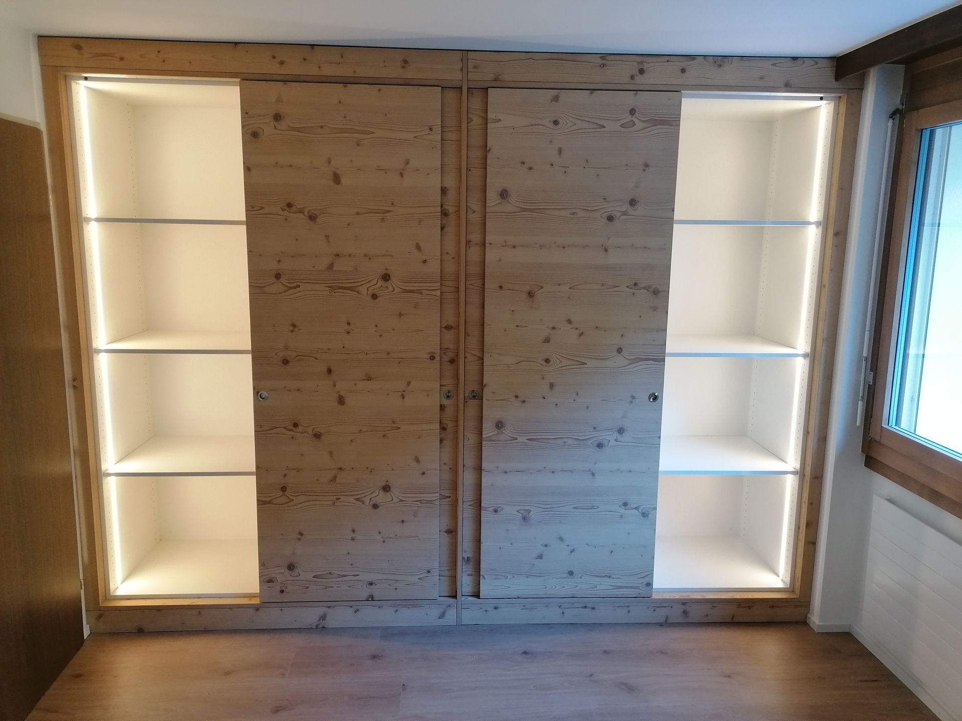 Ein Holzschrank auf einem Balkon mit Blick auf einen schneebedeckten Berg. Foto von der Holzprofi Zermatt AG