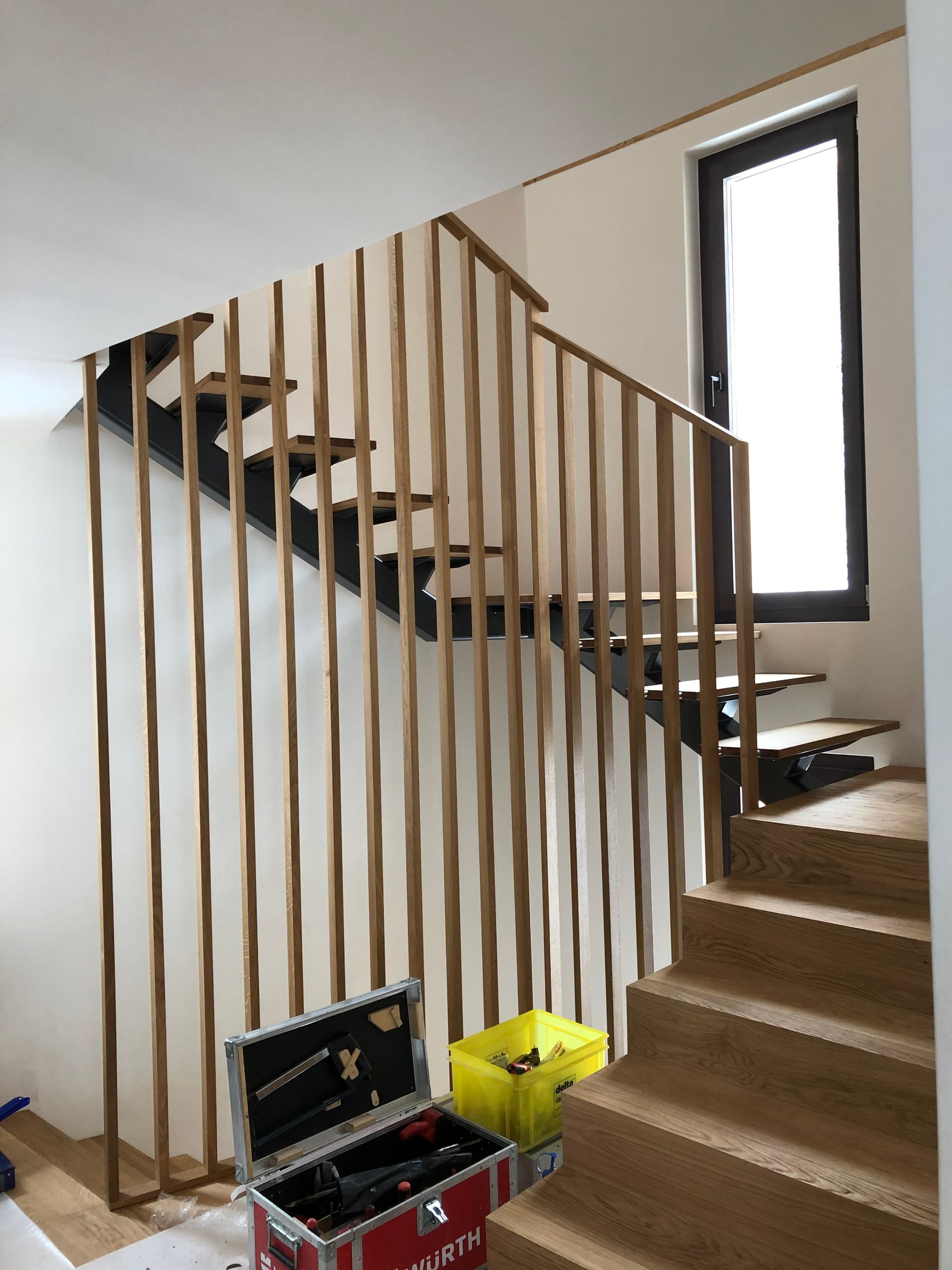 Ein Badezimmer mit Toilette, Waschbecken und Spiegel. Foto von der Holzprofi Zermatt AG