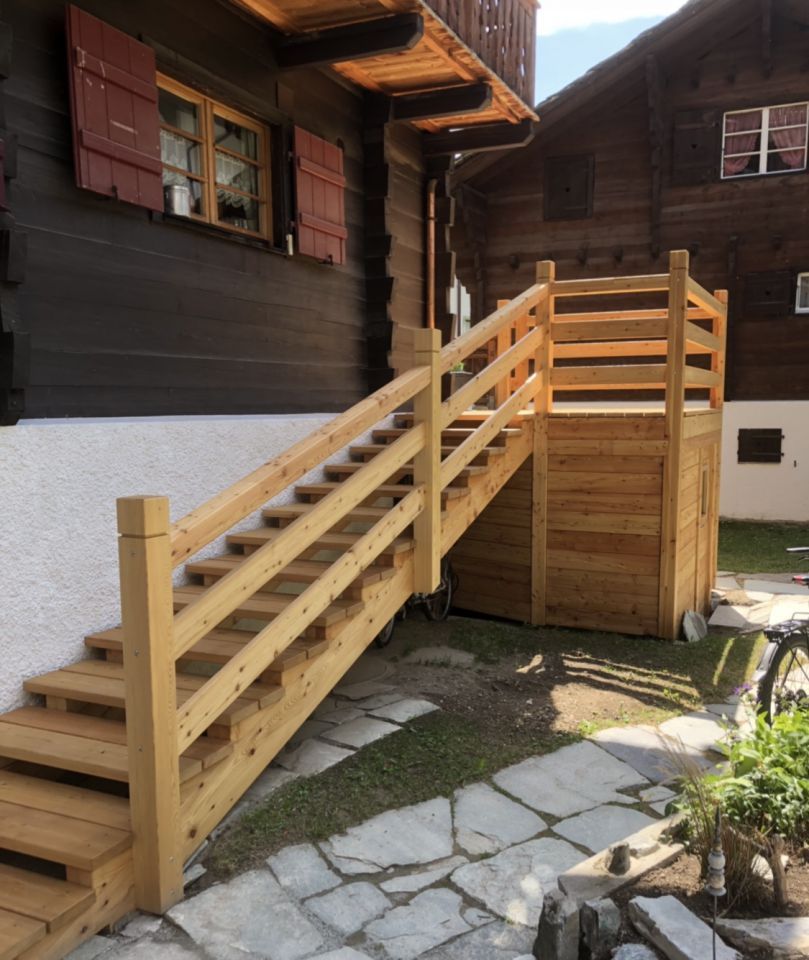 Ein Badezimmer mit Waschbecken, Toilette und Spiegel. Foto von der Holzprofi Zermatt AG