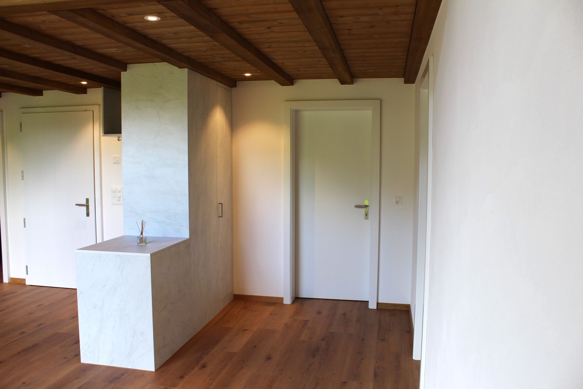 Eine Holztür ist von Weihnachtsdekorationen auf einer Steinmauer umgeben. Foto von der Holzprofi Zermatt AG