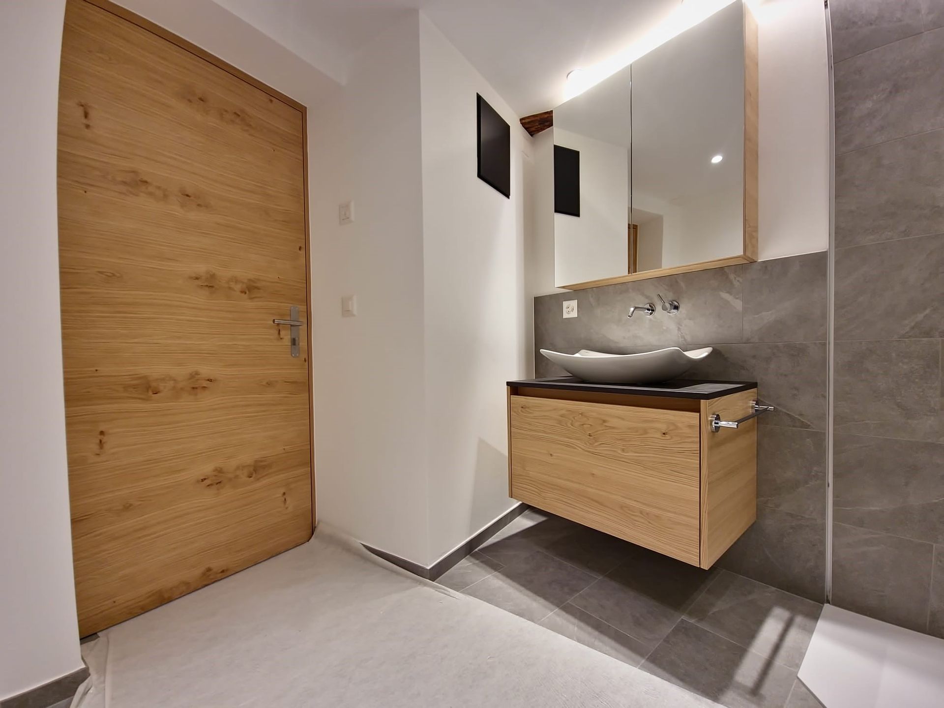 Ein Badezimmer mit zwei Waschbecken und einem Spiegel. Foto von der Holzprofi Zermatt AG