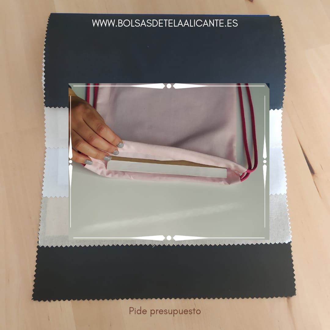 Una imagen de una persona sosteniendo un trozo de tela con la página web www.bolsasdetelaalicante.es