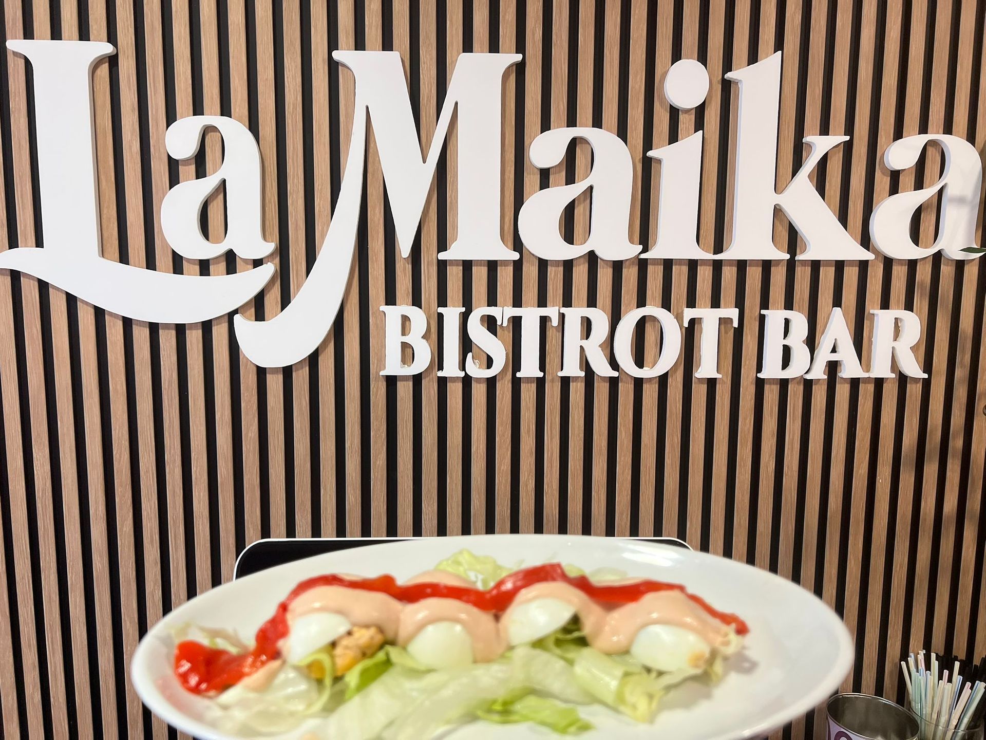 Plato con salsa en plato frente al cartel de 