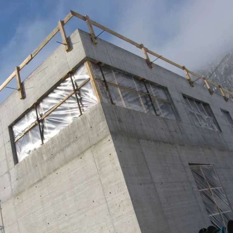 Un grand bâtiment en béton avec une balustrade en bois au sommet