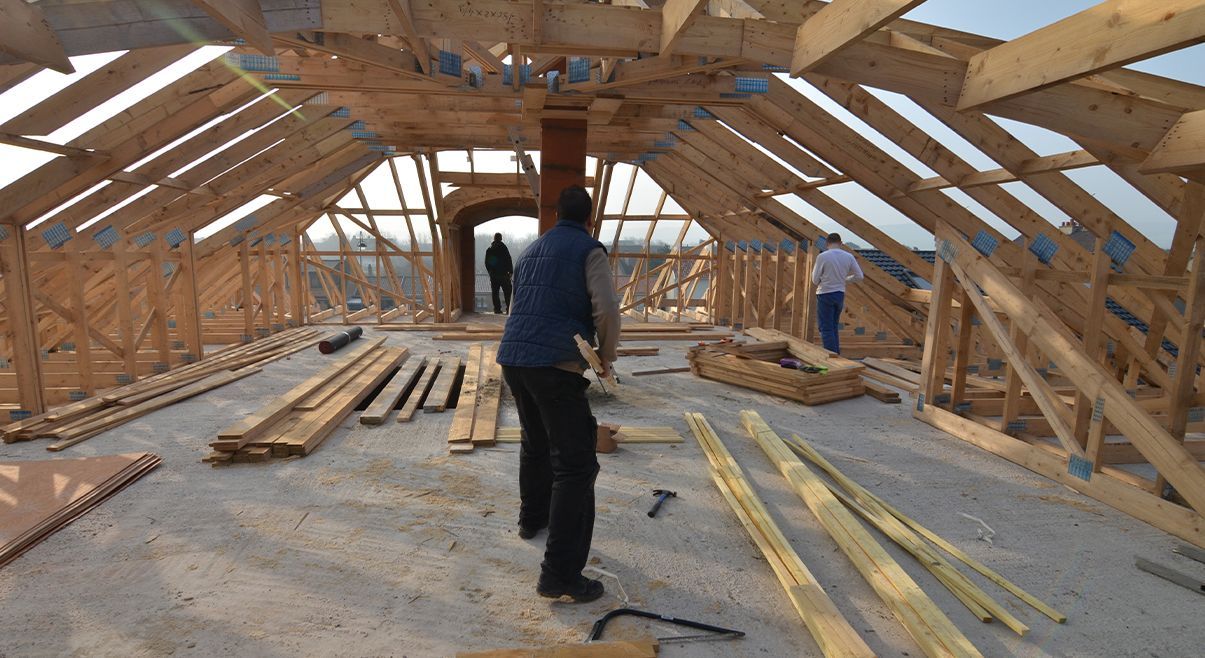 Trois hommes construisent une charpente