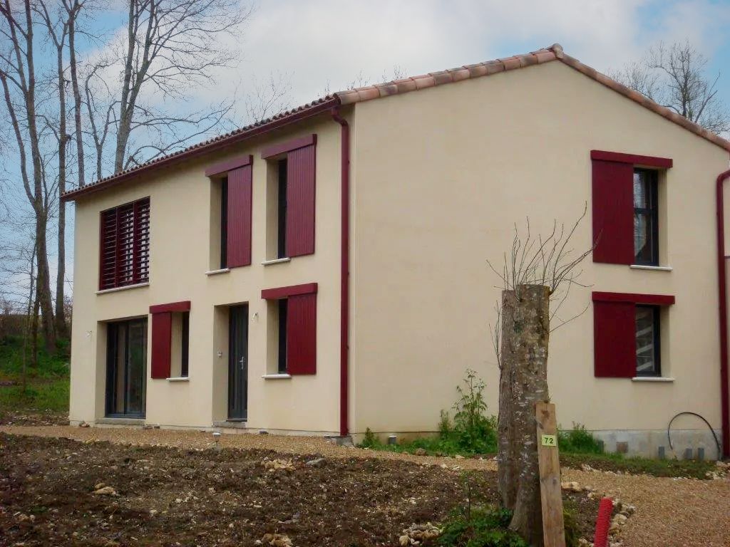 Volets coulissants rouges  sur plusieurs fenêtres d'une maison
