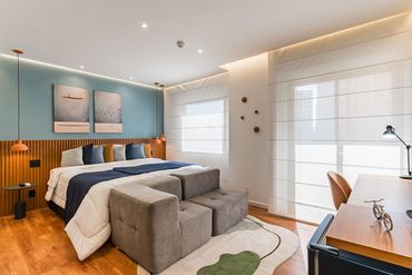 Há uma cama grande no meio do quarto.
