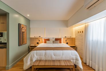 Há uma cama grande no meio do quarto.