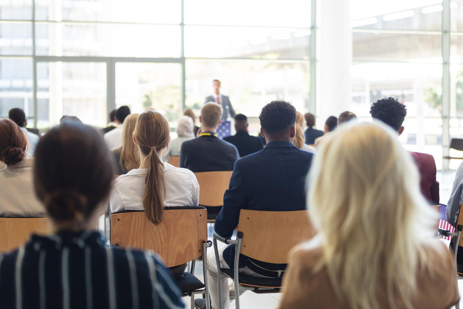 Ein Mann hält vor einer Gruppe von Leuten in einem Konferenzraum eine Präsentation.