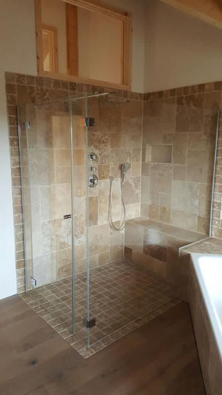 Ein Badezimmer mit ebenerdiger Dusche und Badewanne.