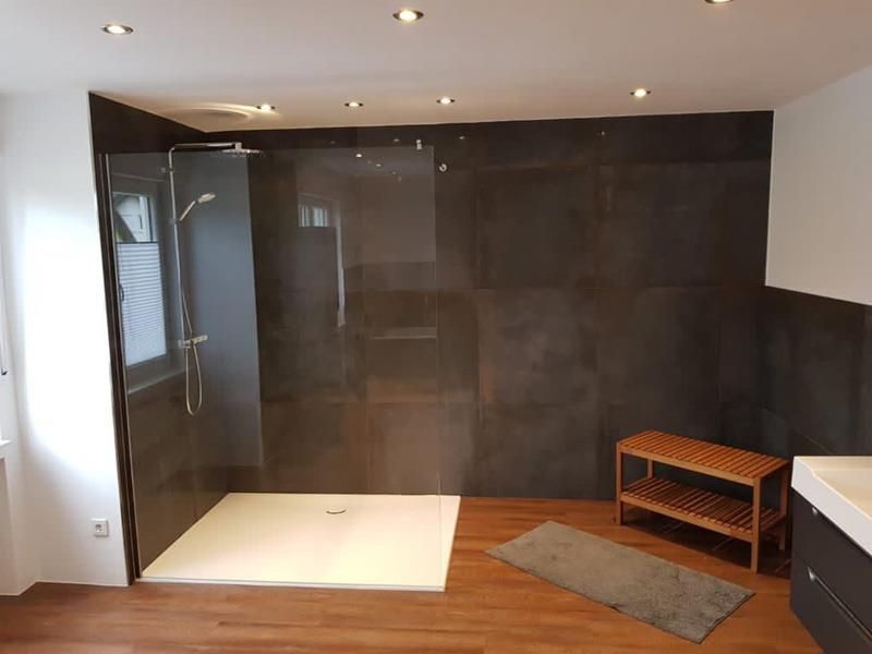 Ein Badezimmer mit ebenerdiger Dusche und einer Sitzbank.