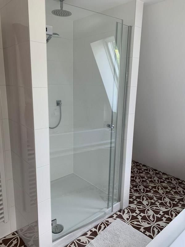 Ein Badezimmer mit ebenerdiger Dusche und Badewanne.