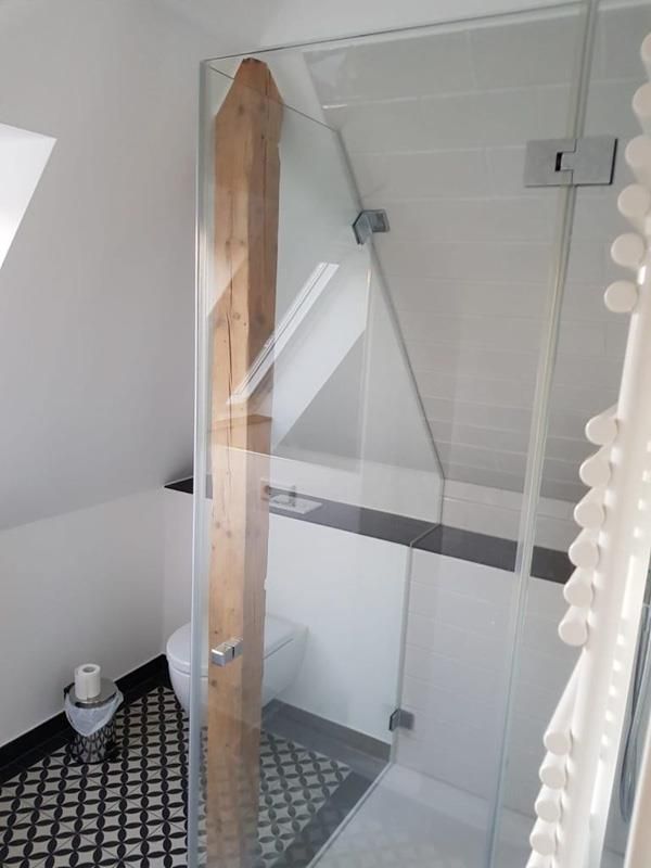 Ein Badezimmer mit Toilette und Glasduschtür