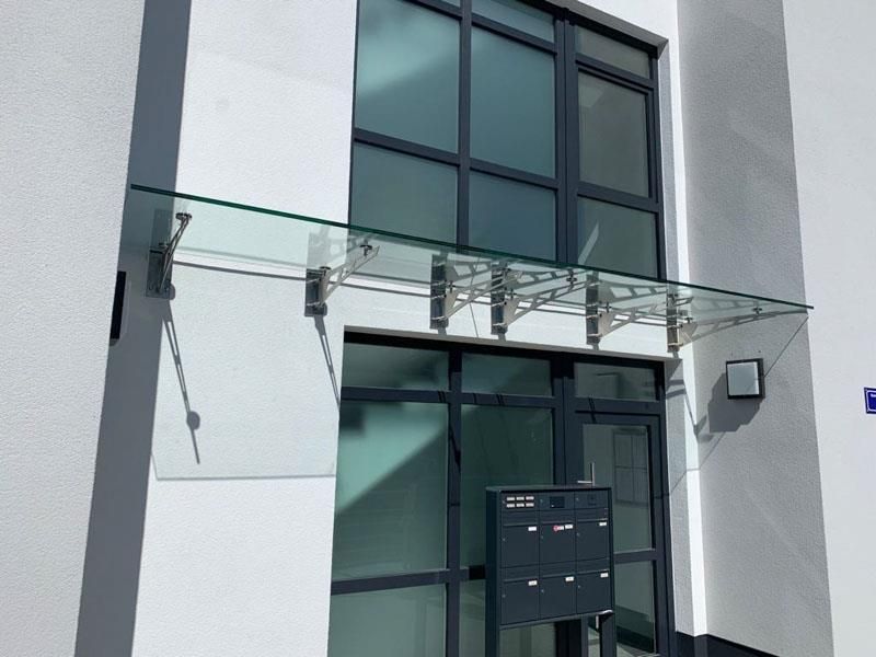 Ein Gebäude mit einem Glasdach über der Tür und einem Briefkasten.